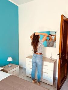 a girl is standing in front of a mirror at Zisa House Casa Vacanze in Palermo