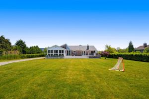 a house with a large yard with a goal at Meadow Beauty in Westhampton Beach