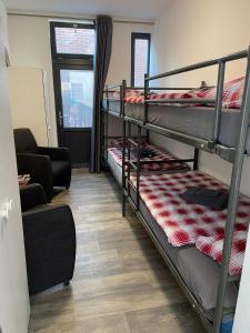 Zimmer mit 2 Etagenbetten und einem Stuhl in der Unterkunft Restaurant Hostel Aan Tafel in Lunteren