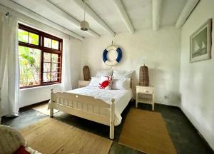 a bedroom with a white bed and a window at Tranquility in Hermanus