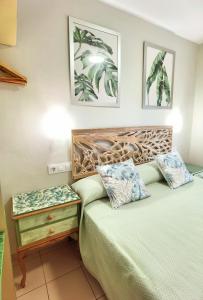 a bedroom with a bed and a night stand next to a bed at HOSTAL RIGAU in Sant Feliu de Guixols