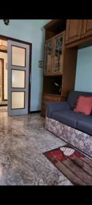 ein Wohnzimmer mit einem blauen Sofa und einer Tür in der Unterkunft La Casa Di Edy in Borzonasca