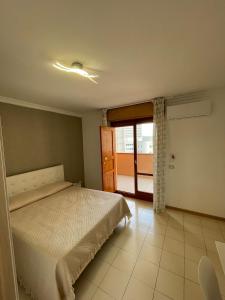 a bedroom with a bed and a sliding glass door at Ce sta 'o mar for in Naples