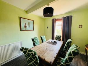 comedor con mesa de madera y sillas en Park Road Holiday Home en Rosyth