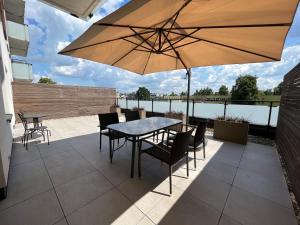 a patio with a table and chairs and an umbrella at Apartament Symfonia Mozarta in Warka