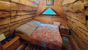 - une petite chambre avec un lit dans une cabane en rondins dans l'établissement Noclegi Domki NIEDŹWIEDZIA GÓRKA, à Czarna