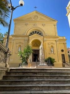 a large yellow building with stairs in front of it at Sanremo Apartments - Marilux in Sanremo