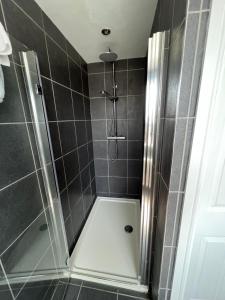 a shower with a glass door in a bathroom at 3 bed luxury open plan living in Rayleigh