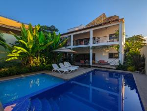 une villa avec une piscine en face d'une maison dans l'établissement Departamento Los Gallos, tercer piso gran terraza, à Lo de Marcos