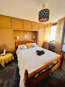 1 dormitorio con 1 cama grande y cabecero de madera en Park Road Holiday Home, en Rosyth