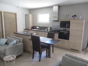 a kitchen and living room with a table and chairs at LA MASTRONA in Saumane-de-Vaucluse