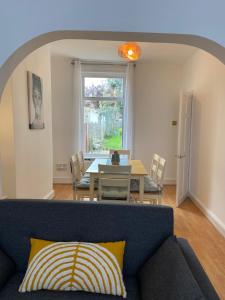 a living room with a couch and a table at Elizabeth Line Garden home in Ilford