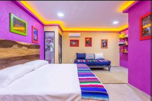 a pink bedroom with a bed and a couch at Numa Hotel Boutique in Playa del Carmen +72 photos