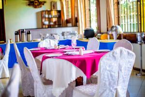 a table with white chairs and a pink table cloth at MBEYA PARADISE INN in Mbeya