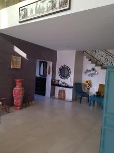 - un salon avec un grand vase sur le mur dans l'établissement Villa AKWABA, à Aït Ourir