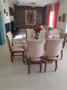 une salle à manger avec une table et des chaises en verre dans l'établissement Villa AKWABA, à Aït Ourir