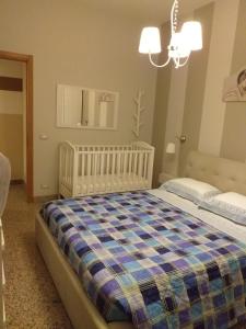 a bedroom with a bed with a crib in it at TONNARA HOUSE AND HOLIDAY in Avola