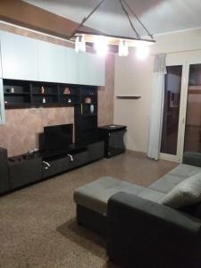 a living room with a couch and a television at TONNARA HOUSE AND HOLIDAY in Avola