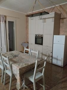 a kitchen with a table and chairs and a refrigerator at TONNARA HOUSE AND HOLIDAY in Avola