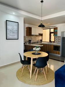 een eetkamer en een keuken met een tafel en stoelen bij Mid-Century 1 bedroom apartment in Nairobi