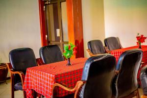a conference room with two tables and chairs with red table cloth at MBEYA PARADISE INN in Mbeya