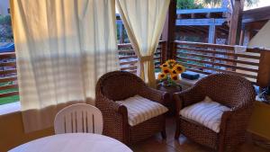two wicker chairs and a table on a porch at Villetta Vista Mare Cornino in Custonaci