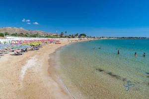 a beach with a bunch of people in the water at TONNARA HOUSE AND HOLIDAY in Avola