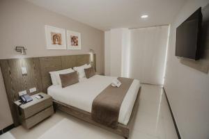 1 dormitorio con 1 cama grande y TV de pantalla plana en Hotel Marrakech Cali, en Cali