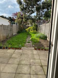 un patio con una valla y una acera con plantas en Elizabeth Line Garden home, en Ilford