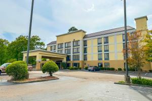 un gran edificio amarillo con coches aparcados en un aparcamiento en OYO Townhouse Jackson - Ridgeland, en Jackson