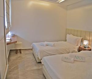 a hotel room with two beds and a desk at AKS Home appart 2 - CABONEGRO in Cabo Negro