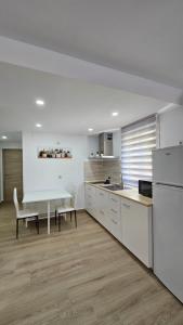 a white kitchen with a table and a table and chairs at Apartamento Trajano in Santiponce