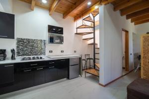 una cocina con armarios negros y una escalera de caracol en Ursus, Mi casita en México en Ciudad de México