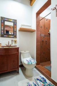 a bathroom with a toilet and a sink and a shower at Ursus, Mi casita en México in Mexico City +31 photos