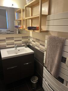 a bathroom with a sink and a towel at Maison 6km de Sarlat piscine chauffée et jacuzzi in Saint-Vincent-le-Paluel