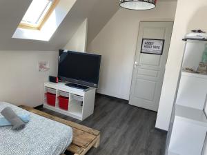 a living room with a flat screen tv and a door at Maison 6km de Sarlat piscine chauffée et jacuzzi in Saint-Vincent-le-Paluel