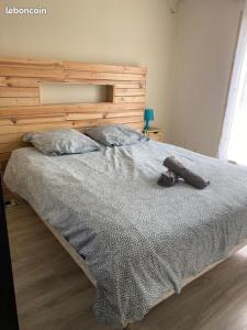 a bedroom with a large bed with a wooden headboard at Maison 6km de Sarlat piscine chauffée et jacuzzi in Saint-Vincent-le-Paluel +24 photos