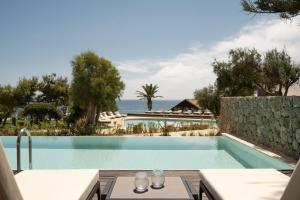 a swimming pool with a view of the ocean at Domes of Corfu, Autograph Collection in Glyfada