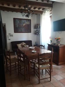 uma sala de jantar com uma mesa de madeira e cadeiras em Casa Luna em Tavernelle