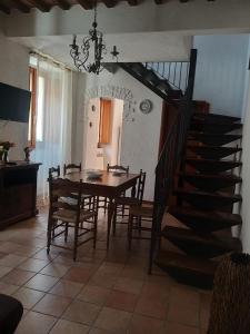 uma sala de jantar com uma mesa e uma escada em Casa Luna em Tavernelle