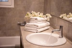 a bathroom with a sink and towels on a counter at Nest Aegina Apartments in Perdika