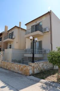 a large house with a fence and a street light at Nest Aegina Apartments in Perdika