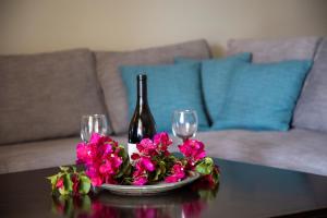 a table with two wine glasses and flowers on it at Nest Aegina Apartments in Perdika