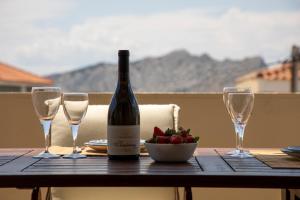 a bottle of wine and two glasses on a table at Nest Aegina Apartments in Perdika +33 photos