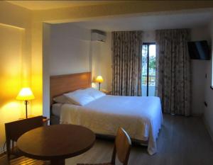 a hotel room with a bed and a table at Hotel Palmas de La Serena in La Serena