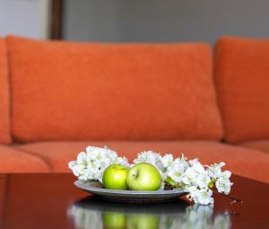 a plate of apples and flowers on a table at Nest Aegina Apartments in Perdika