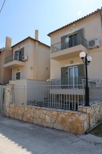 a building with a fence and a street light in front at Nest Aegina Apartments in Perdika