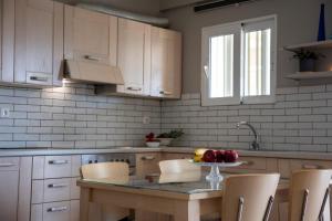 a kitchen with a table with a bowl of fruit on it at Nest Aegina Apartments in Perdika