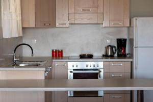 a kitchen with a sink and a white refrigerator at Nest Aegina Apartments in Perdika
