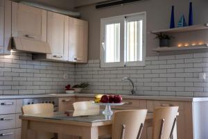 a kitchen with a table with a bowl of fruit on it at Nest Aegina Apartments in Perdika
